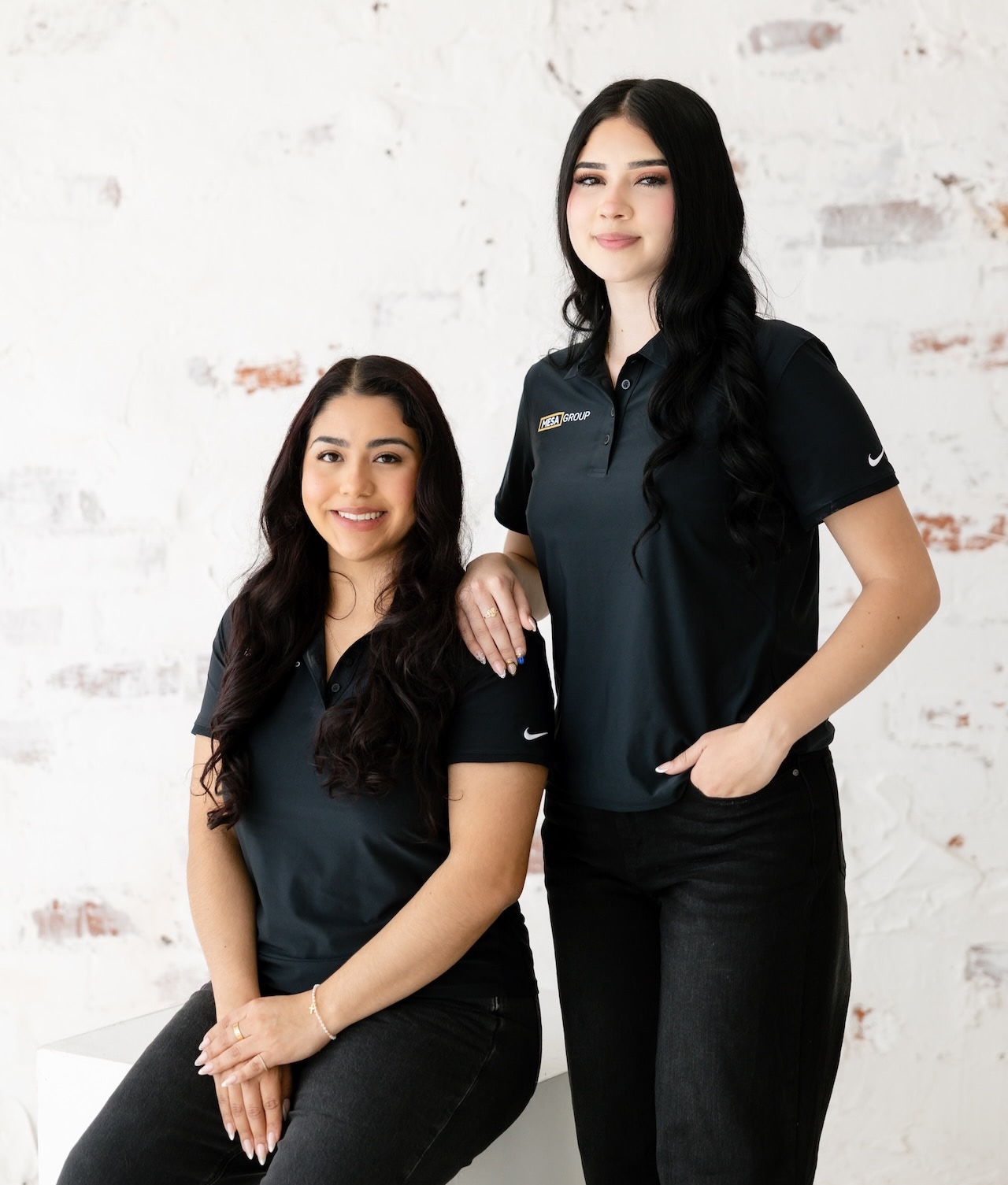 Aileen Calderon and Carmen Alvarez Perez of Mesa Group Consulting smiling in a professional portrait