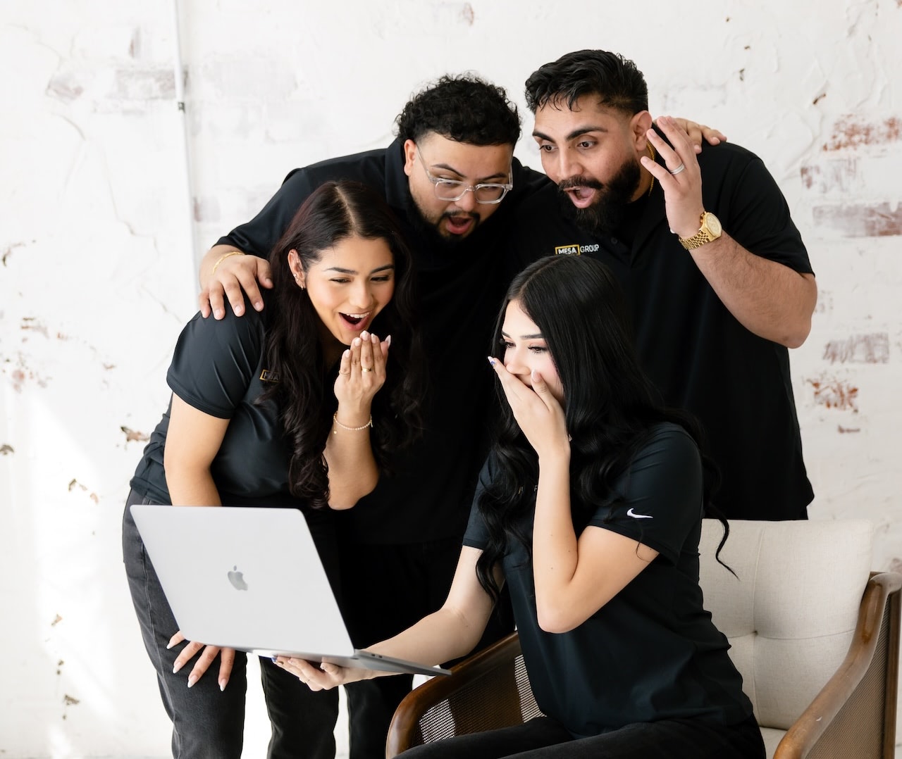 Mesa Group Consulting team reacting with excitement to results on a laptop during a strategy session